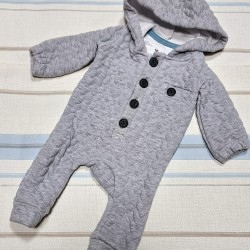 Бебешки капитониран преходен гащеризон в сиво с качулка Бебешки капитониран преходен гащеризон в сиво с качулка